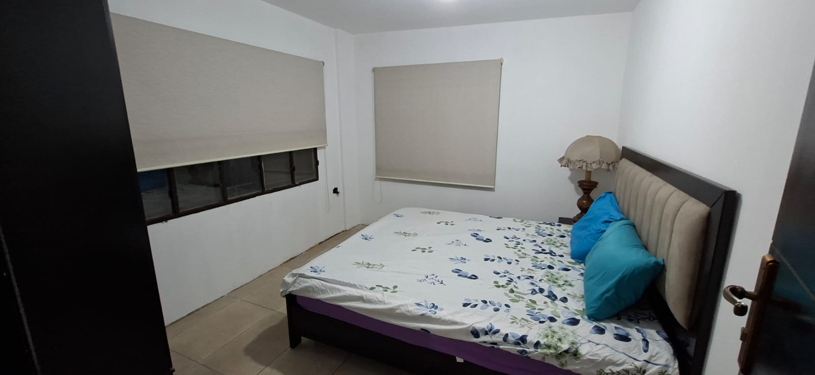 Chalet bedroom with floral sheets and lamp