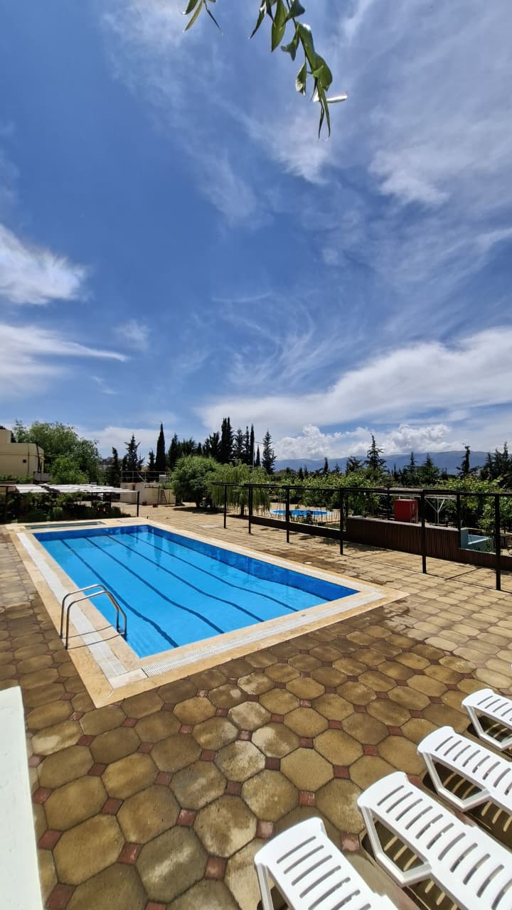 Wide view of Sama Anjar pool under summer sky