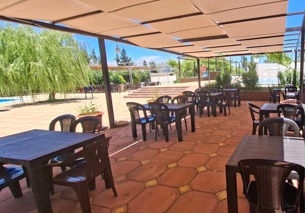 Outdoor restaurant terrace with tables and canopy at Sama Anjar